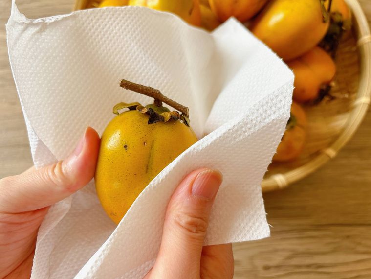 柿をキッチンペーパーで拭く様子