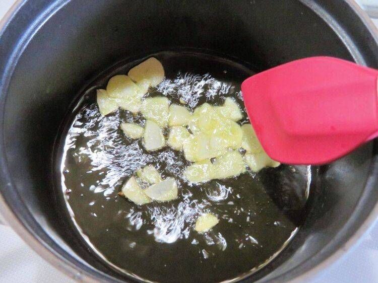 鍋でにんにくスライスを炒める