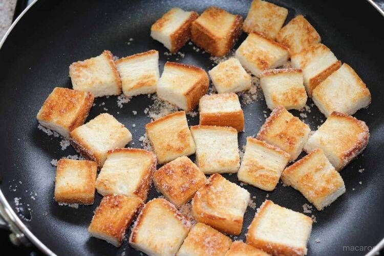 フライパンに入ったグラニュー糖をまぶした食パンラスク
