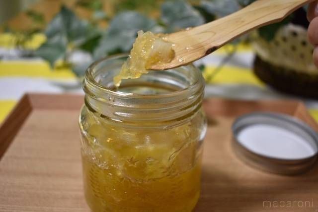 瓶に詰めたレモンジャムを、木のスプーンですくっている様子