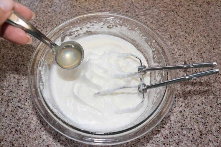 ボウルに入ったメレンゲとレモン汁とハンドミキサーのビーター部分