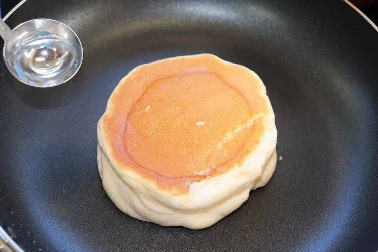 パンケーキが入ったフライパンと大さじに入ったお湯