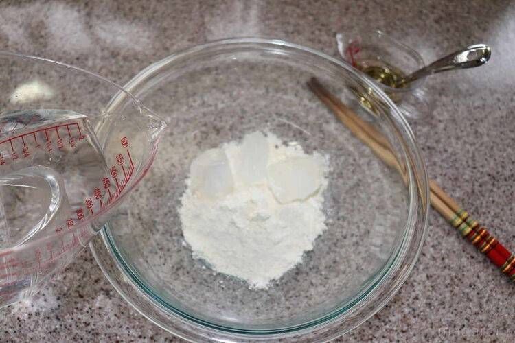 薄力粉と氷が入ったボウル、計量カップに入った水と酢