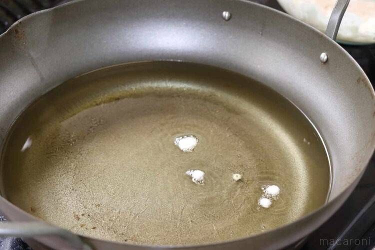 天ぷら鍋に入った油と数滴の衣