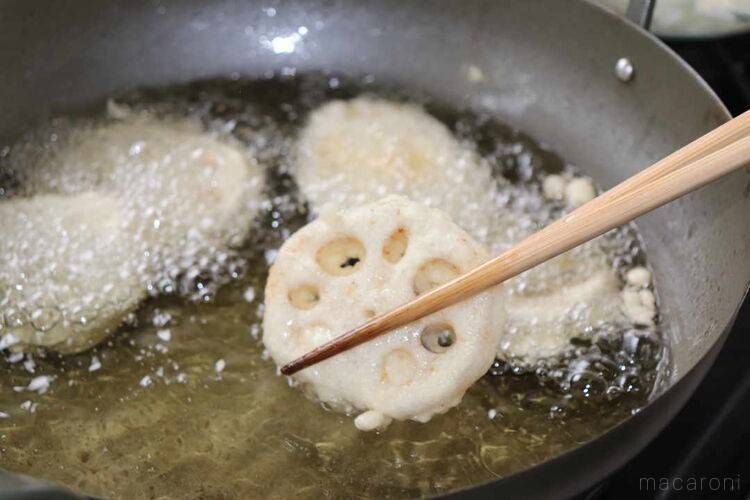 菜箸でれんこんの天ぷらを取り上げている画像