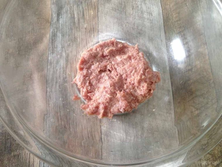 透明のボウルに豚ひき肉と調味料を入れて練ったもの