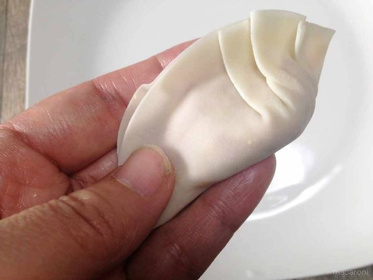 餃子の皮の右側にひだを3回作り、閉じて包んだ様子