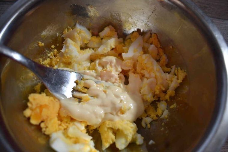 つぶしたゆで卵にフォークでマヨネーズを混ぜている様子