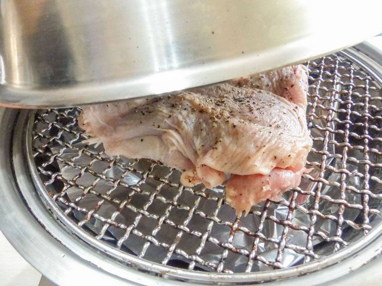 燻製機にセットした鶏肉と、燻製機の蓋を閉める様子