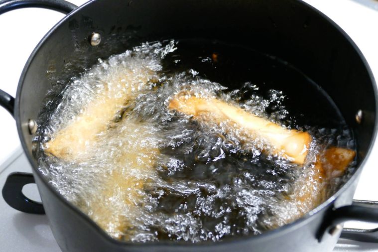 チーズを巻いた餃子の皮を油鍋で揚げる様子