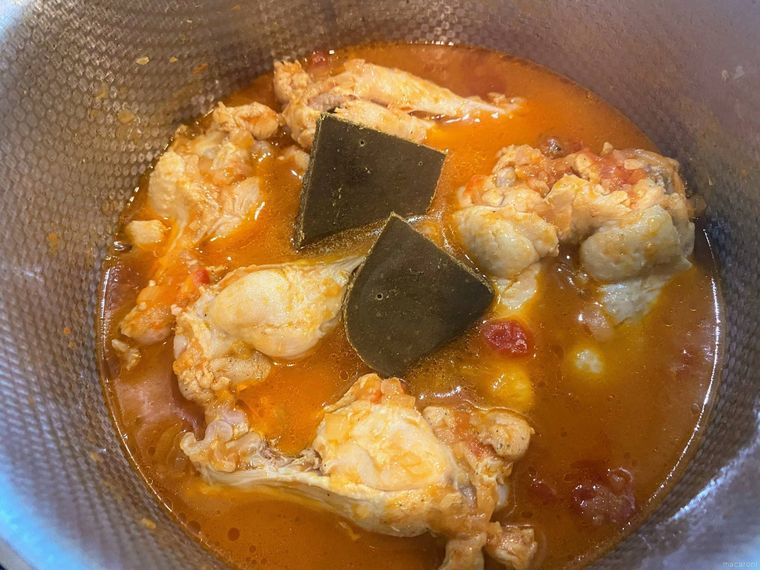 煮込まれた鶏手羽元にカレールーを入れる様子