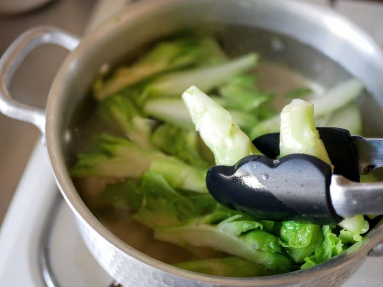 ゆでた子持ち高菜をトングで取り出している