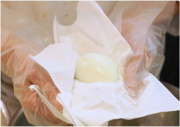 ペーパータオルでゆで卵を拭き、カットする様子