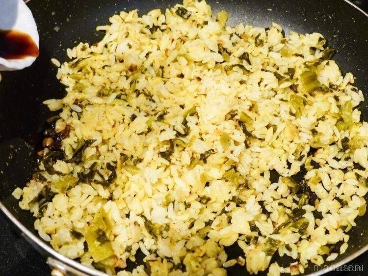 高菜チャーハンに塩こしょうを加えている様子