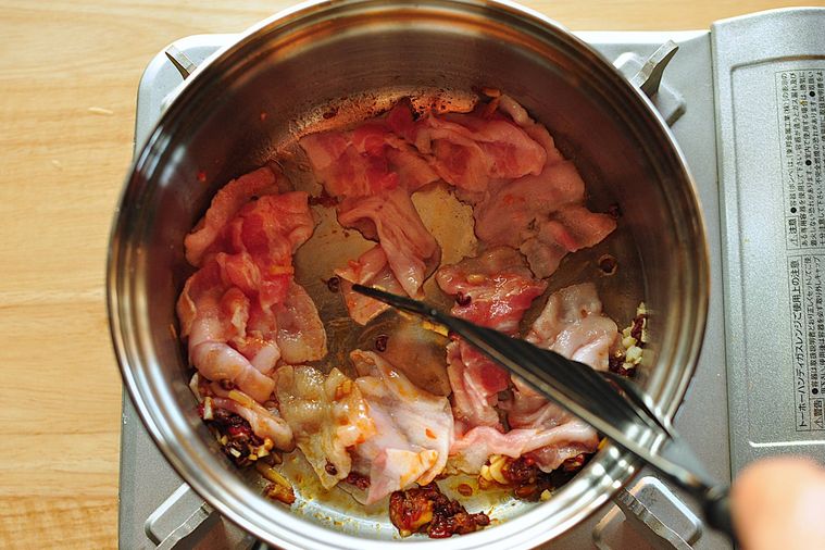 鍋で豚バラ肉を炒める様子