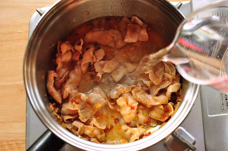 鍋にスープの材料を加える様子