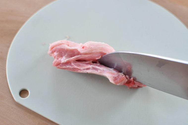 スペアリブの骨に沿って切り込みを入れる様子