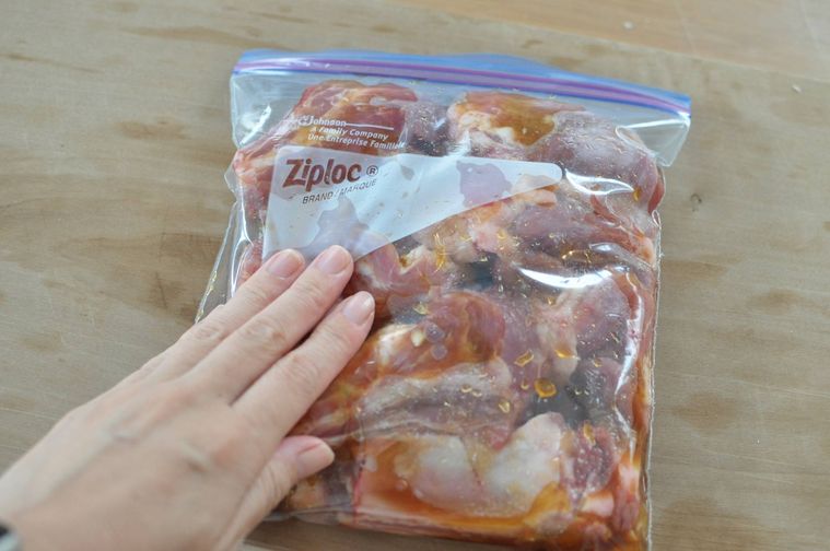 ジップ付き保存袋にスペアリブと漬け込み調味料を入れて味を染み込ませる様子