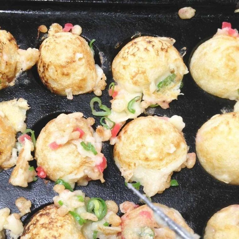 たこ焼きピンで、たこ焼きを返している様子