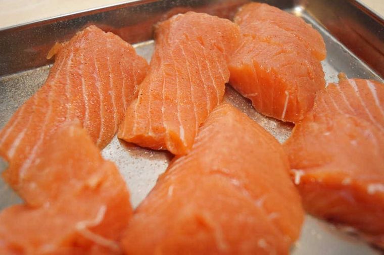 バットで鮭に下味を付けている様子