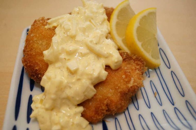 青い和柄の白い皿に盛り付けられた鮭フライ