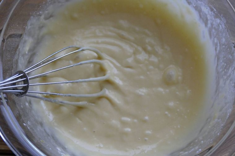 粉類と卵液を泡だて器で混ぜる様子