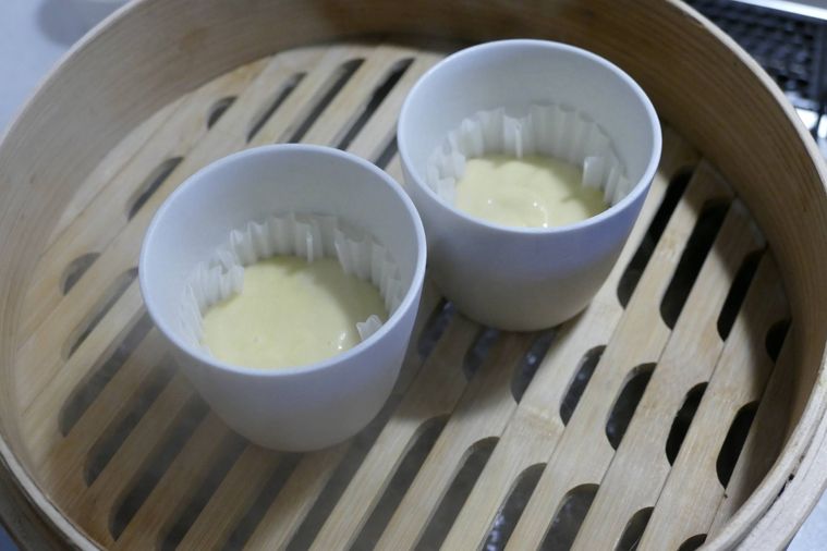 蒸気が出ている蒸し器に生地が入っている容器を並べた様子