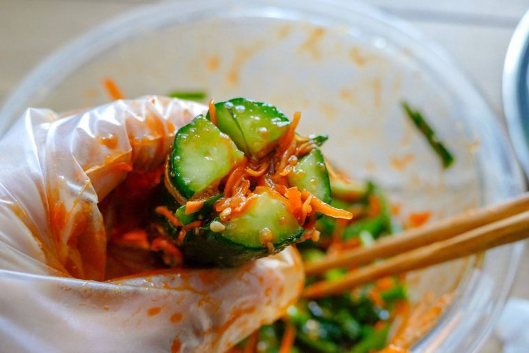 きゅうりの切り込みに野菜を詰め込む様子