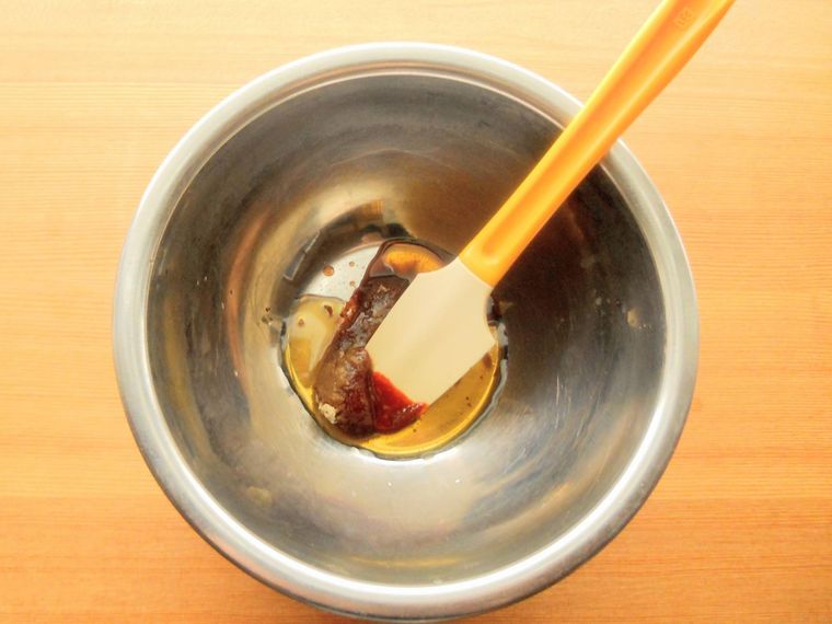 ボウルに入れた調味料を、ゴムベラで混ぜている様子