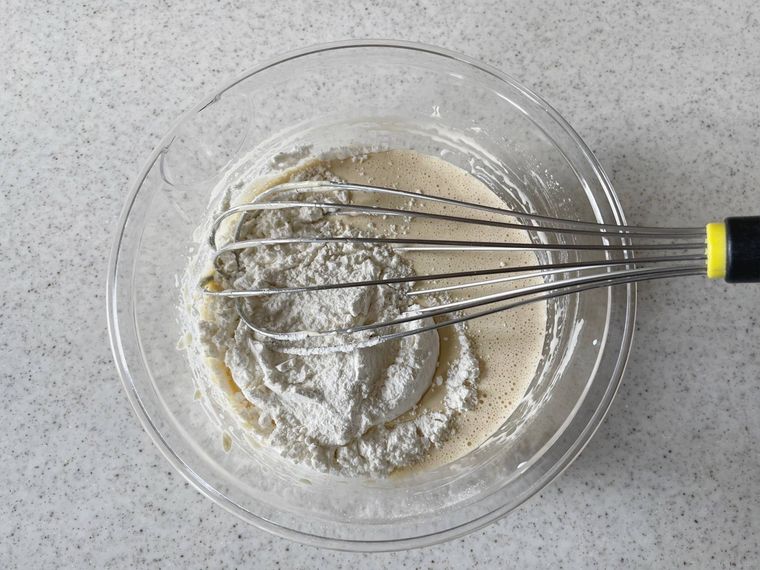 卵黄ときび砂糖を混ぜたボウルに薄力粉を加えた様子