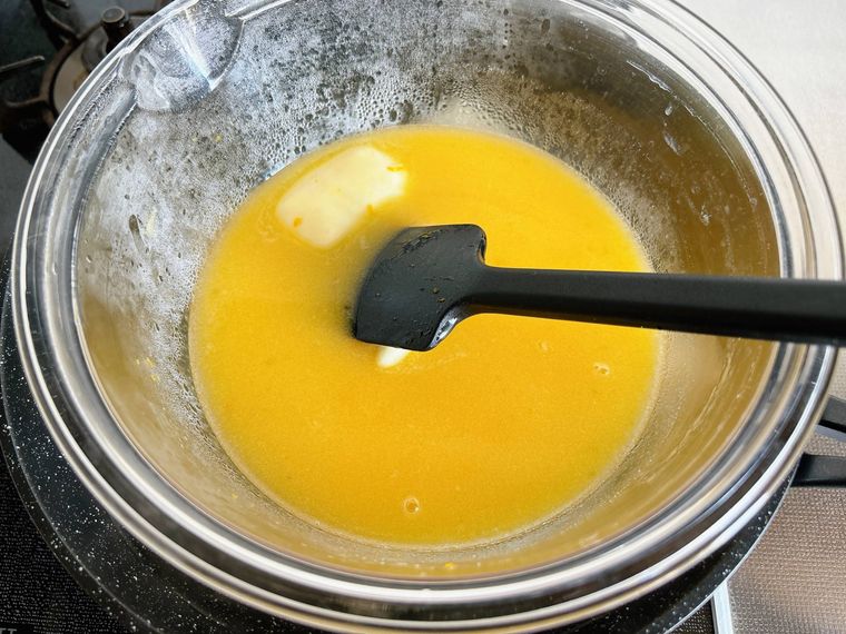 バターを入れた卵液を湯煎にかける様子