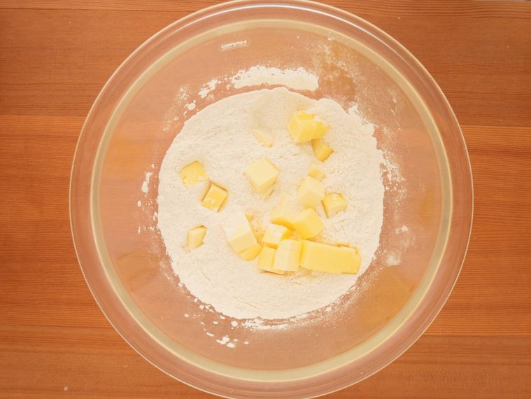 粉類が入ったボウルにバターを加える様子