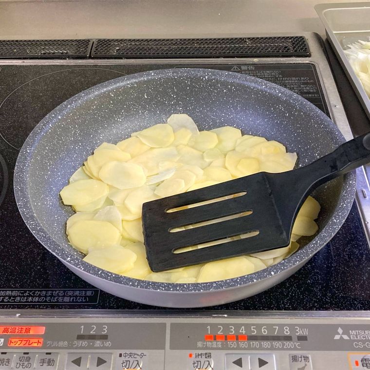 フライ返しでじゃがいもを押さえているところ