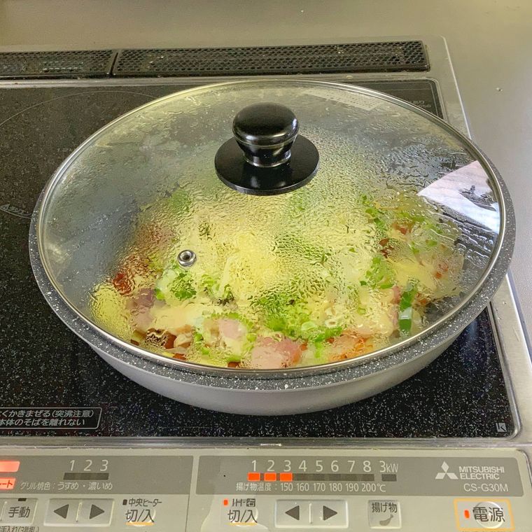 じゃがいもピザのフライパンにふたをして蒸し焼きにしているところ