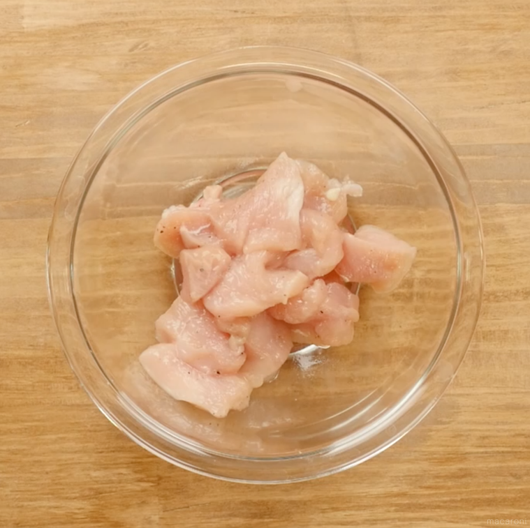 ボウルに入った鶏むね肉に酒を塩コショウを入れて混ぜた様子