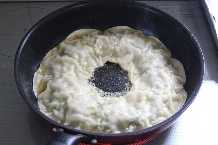 蒸し終えた餃子に焼き目をつけている様子