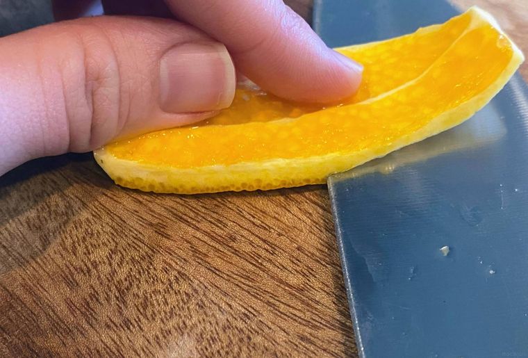 オレンジの皮から中果皮を包丁で削ぐ様子