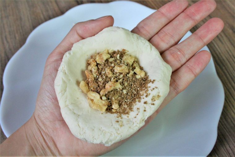 ホットクの生地にローストクルミと黒砂糖を包んでいる様子