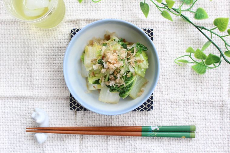 水色のお皿に盛られた白菜おひたしと箸、お茶が並んでいる様子