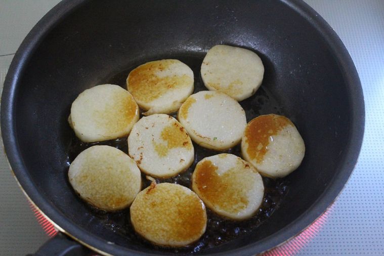 フライパンに焼き目のついた山芋が並べられ、醤油が入っている様子