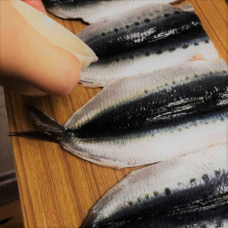 いわしに塩と酒を振っている様子