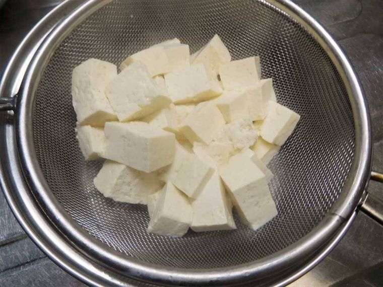 豆腐をザルで水切りしている様子