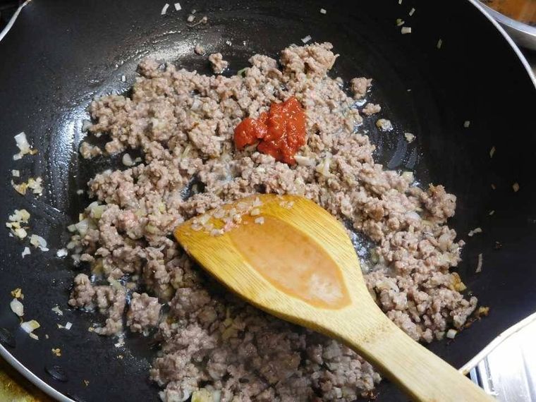 フライパンで炒めたひき肉に豆板醤を加えた様子