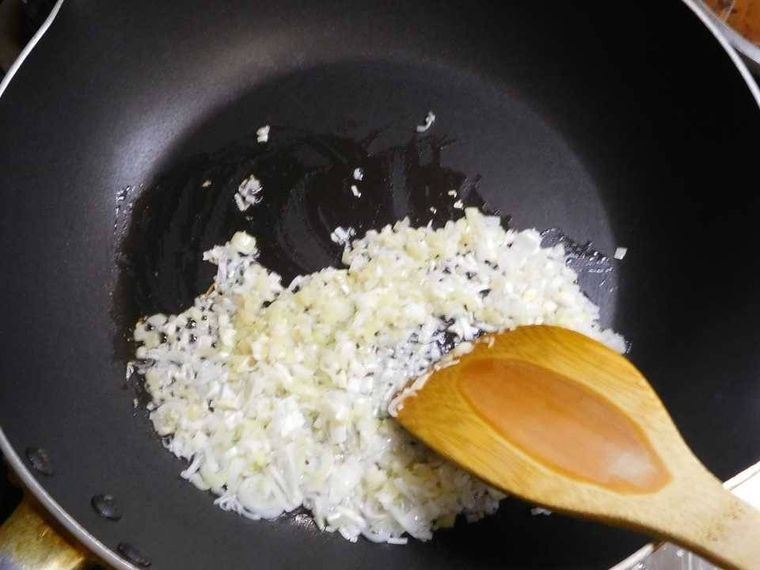 フライパンで長ねぎ、しょうが、にんにくを炒めている様子