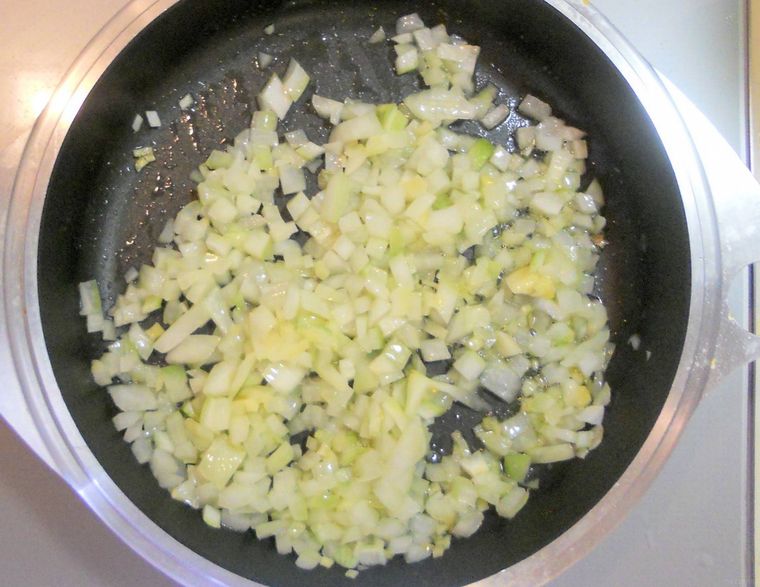 フライパンで玉ねぎとにんにくを炒めている様子