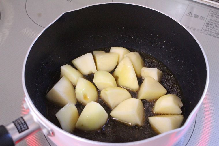 じゃがいもの入った鍋に調味料を入れた様子