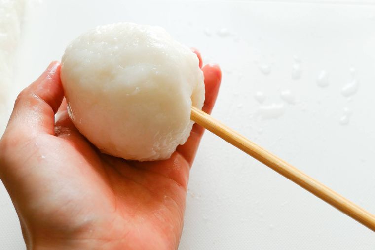 まるめたごはんを割りばしに刺す様子
