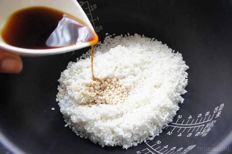 炊飯釜に入っている米に、しょうゆを加えている様子