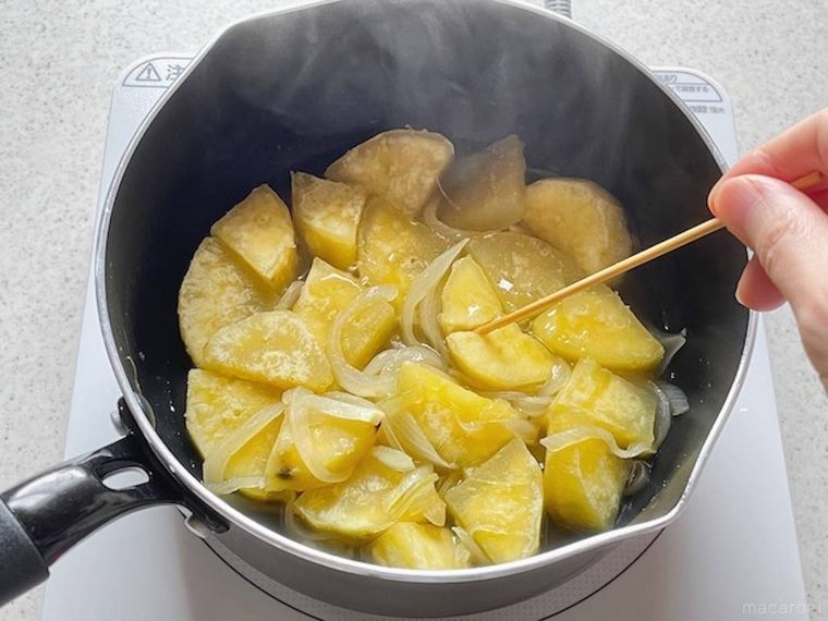 鍋で煮たさつまいもに竹串を刺している様子