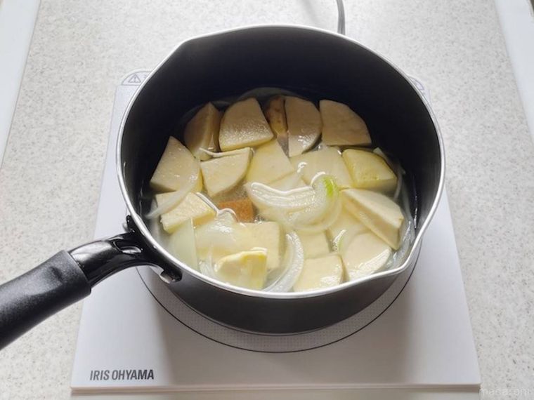 さつまいも炒めた鍋に水とコンソメを入れた様子